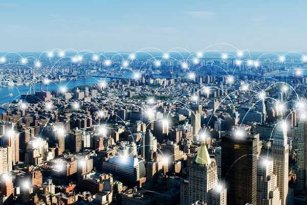 Drahtloses Netzwerk über der Stadt, visualisiert durch weiße Lichtbögen
